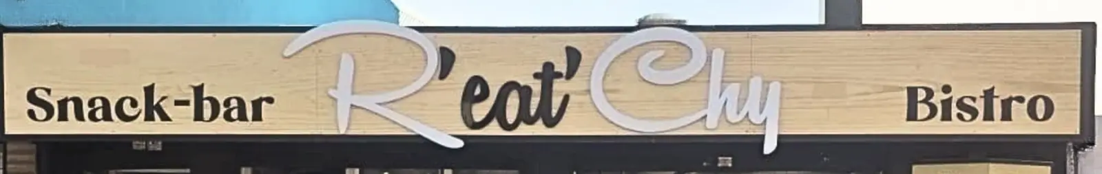 L'enseigne en bois clair de la devanture : Snack-bar, R'eat'Chy en lettres blanches, Bistro